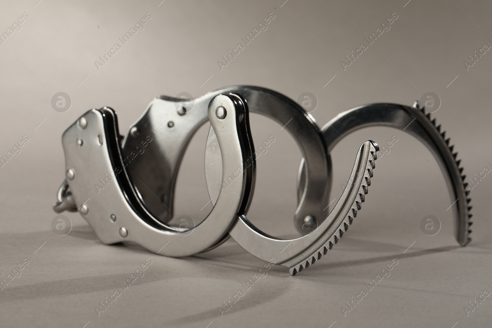 Photo of Metal chain handcuffs on light grey background, closeup