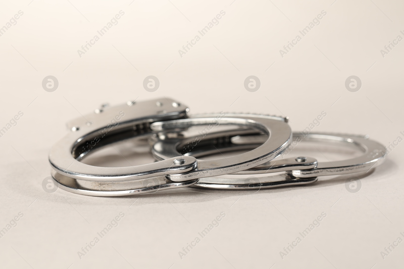 Photo of Metal chain handcuffs on light grey background, closeup