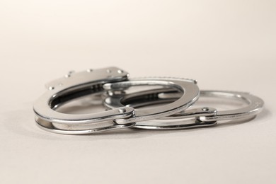 Photo of Metal chain handcuffs on light grey background, closeup