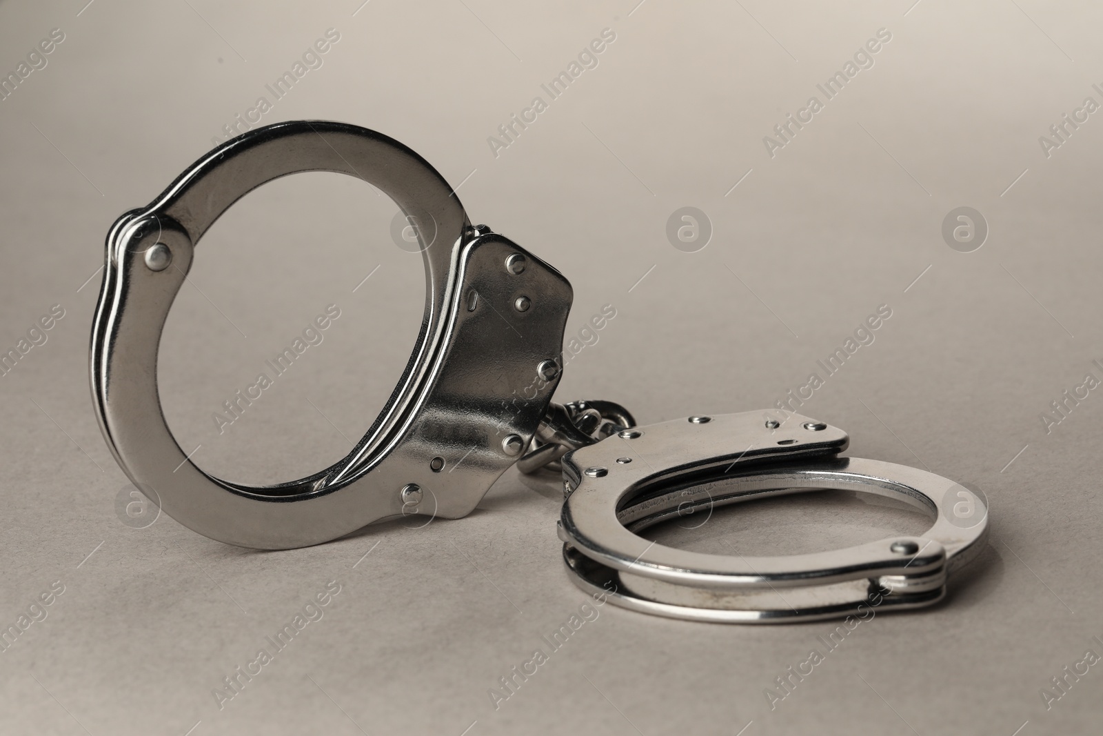 Photo of Metal chain handcuffs on light grey background, closeup