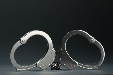 Photo of Metal chain handcuffs on grey background, closeup