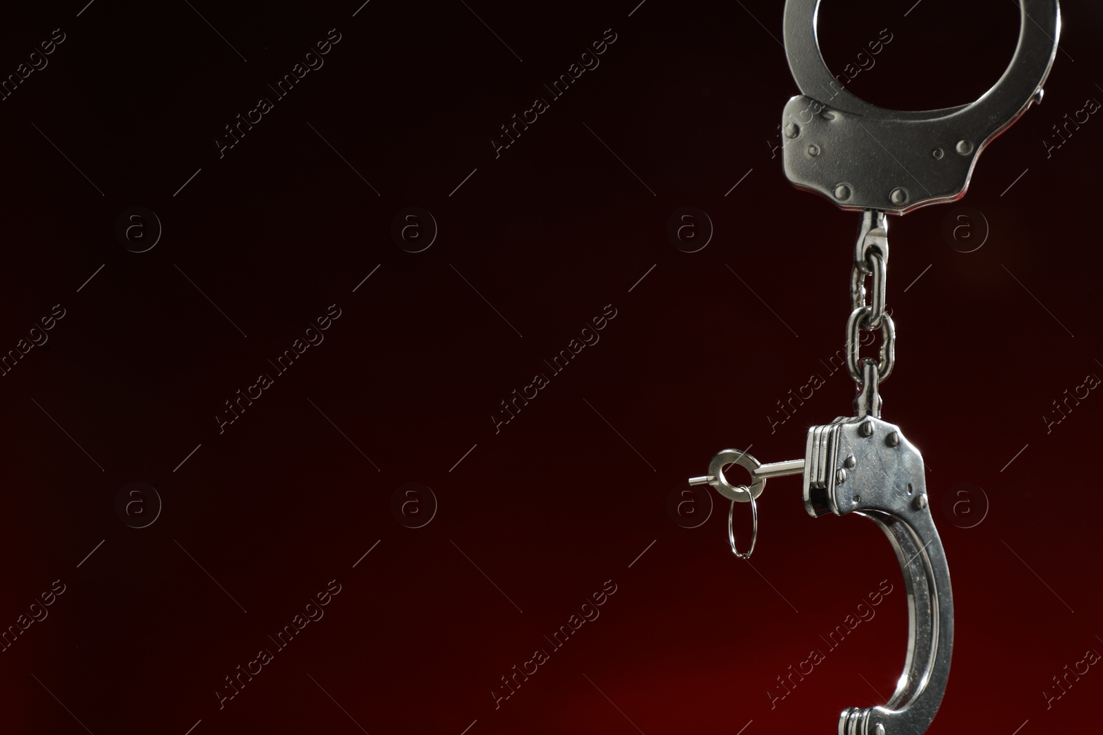 Photo of Metal chain handcuffs on dark background, closeup. Space for text