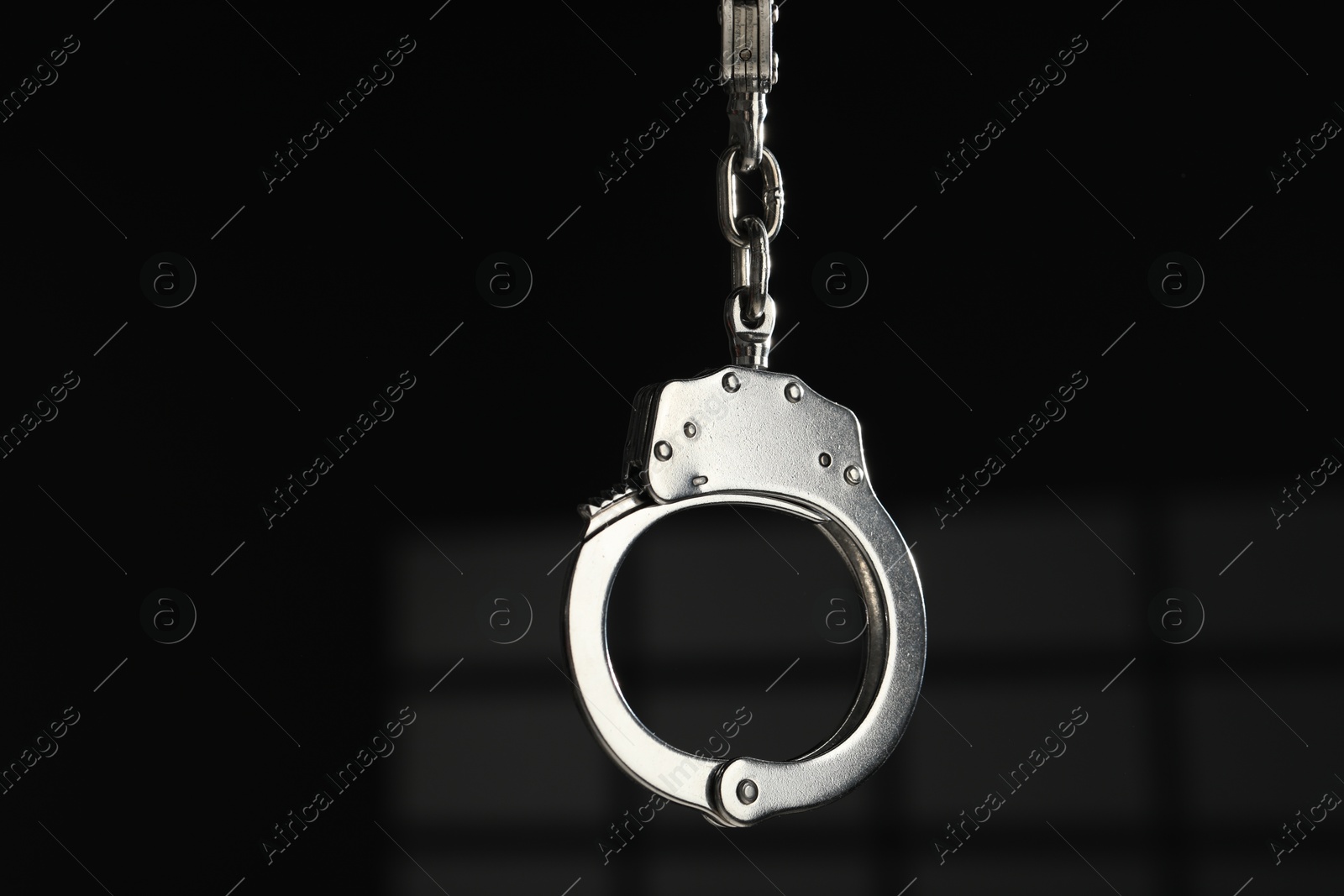 Photo of Metal chain handcuffs on dark background, closeup