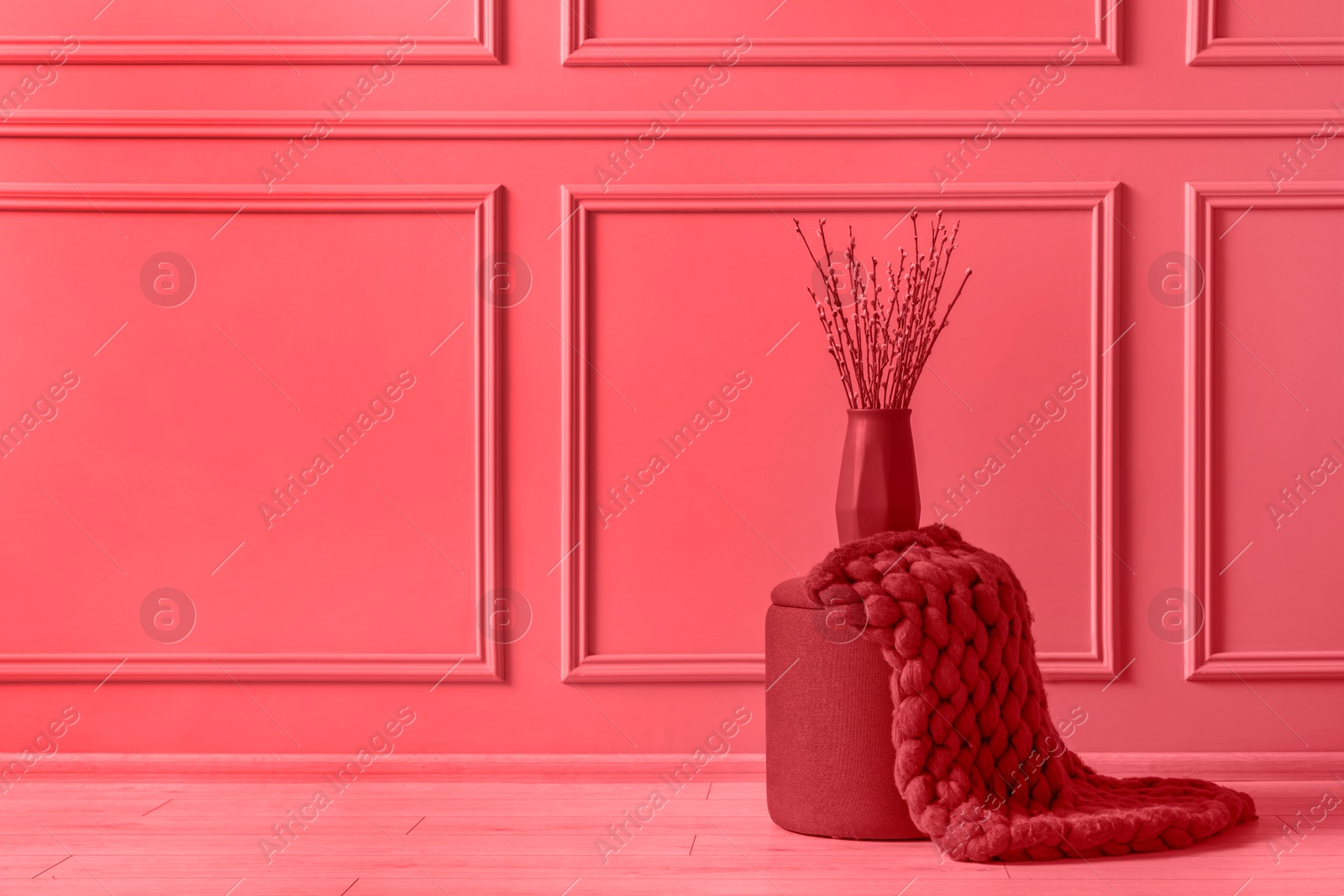 Image of Pouf stool and vase near wall indoors, space for text. Toned in red color