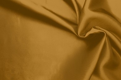 Image of Crumpled golden silk fabric as background, top view. Space for text