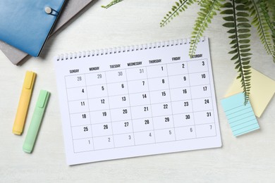 Photo of Timetable. Monthly planner and stationery on white wooden table, flat lay