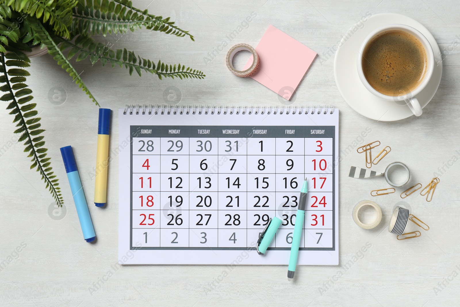 Photo of Timetable. Calendar, coffee and stationery on white wooden table, flat lay