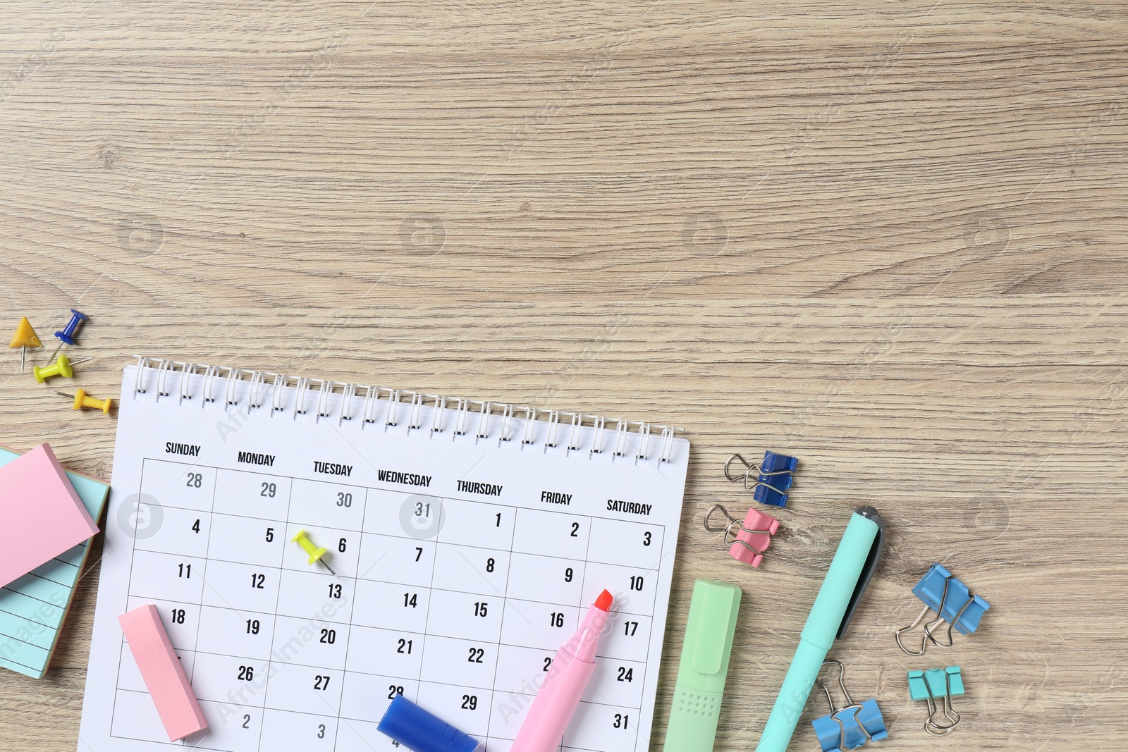 Photo of Timetable. Monthly planner and stationery on wooden table, flat lay. Space for text