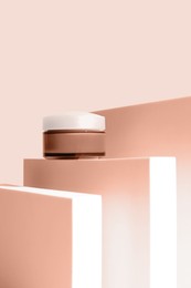 Stylish presentation of facial cream on peach fuzz color background