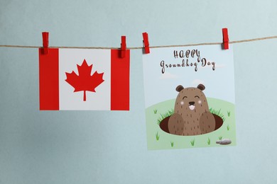 Happy Groundhog Day greeting card and Canada flag hanging against light background