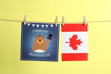 Happy Groundhog Day greeting card and Canada flag hanging on yellow background