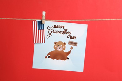 Happy Groundhog Day greeting card and American flag hanging on red background