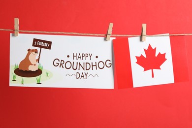 Happy Groundhog Day greeting card and Canada flag hanging on red background