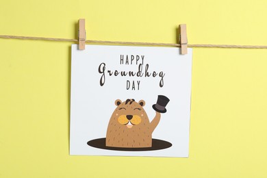 Happy Groundhog Day greeting card hanging on yellow background