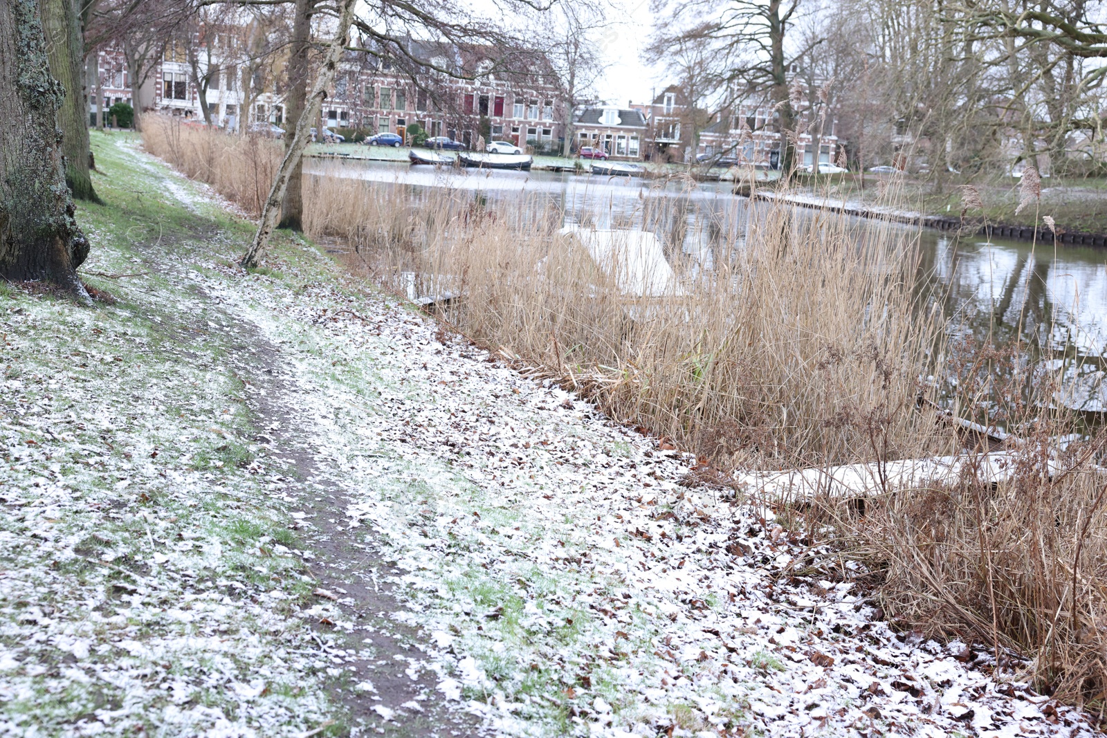 Photo of Picturesque view of water canal, trees and buildings in city on winter day