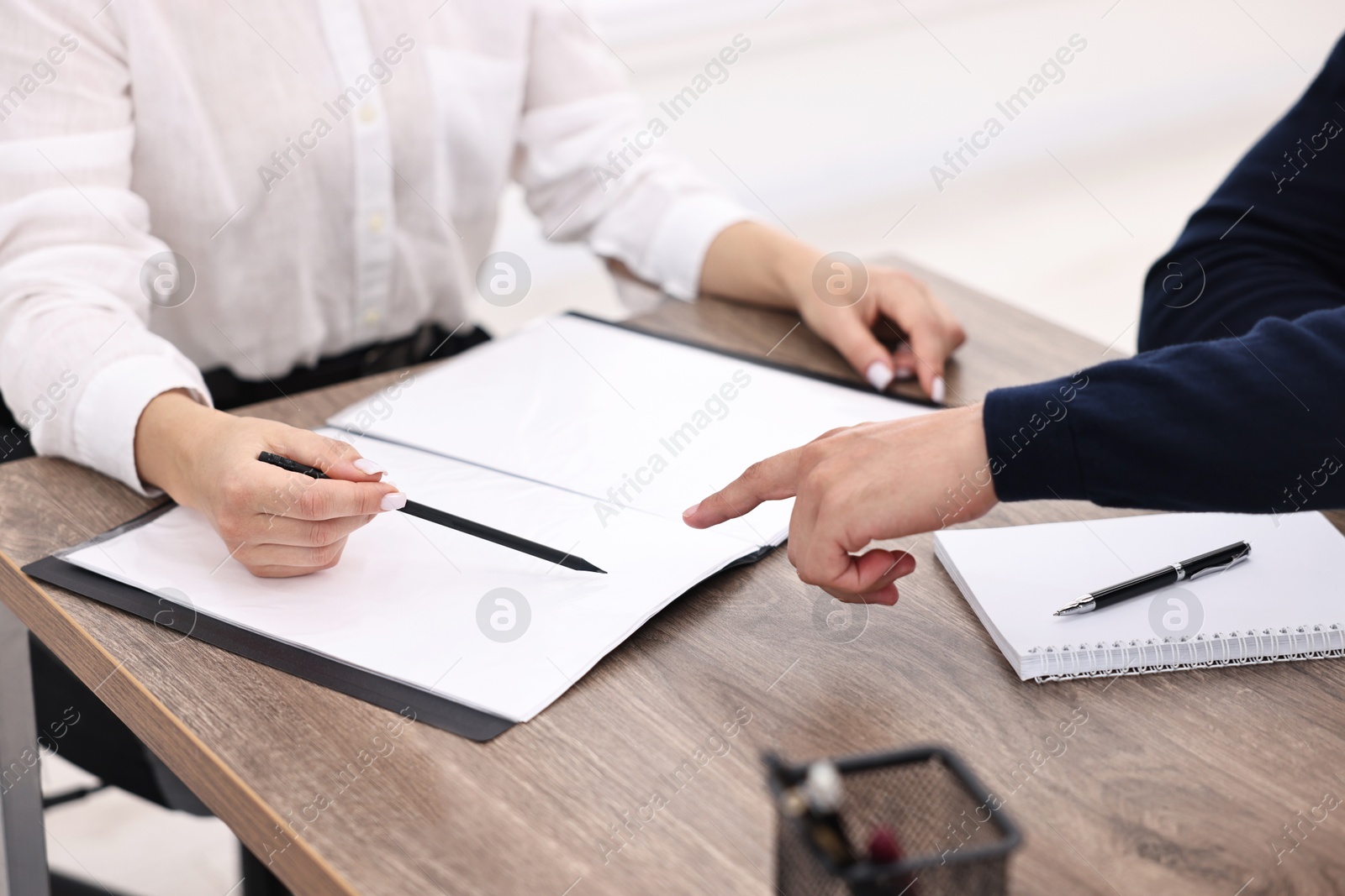 Photo of Banker working with client at wooden table in office, closeup