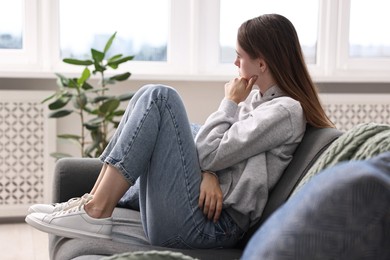 Loneliness concept. Sad teenage girl on sofa at home