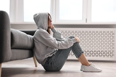 Photo of Loneliness concept. Teenage girl on floor at home