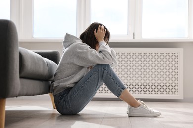 Photo of Loneliness concept. Teenage girl on floor at home