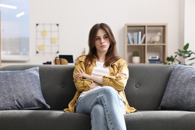 Loneliness concept. Sad teenage girl on sofa at home