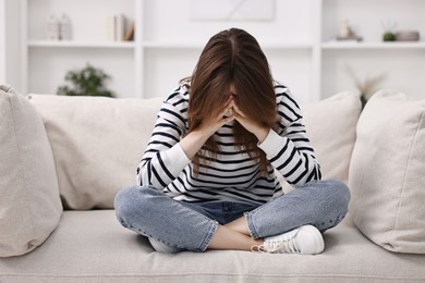 Loneliness concept. Sad teenage girl on sofa at home