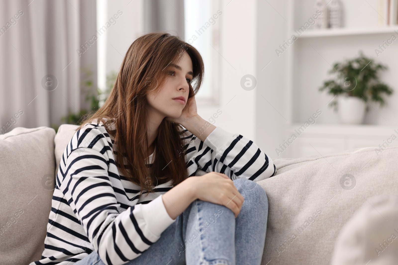 Photo of Loneliness concept. Sad teenage girl on sofa at home