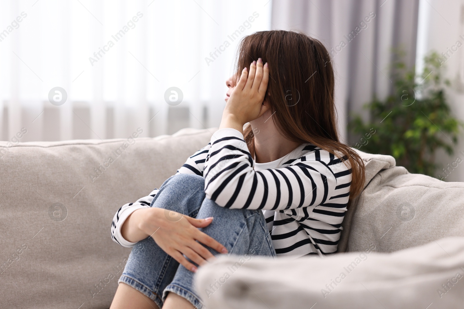 Photo of Loneliness concept. Sad teenage girl on sofa at home