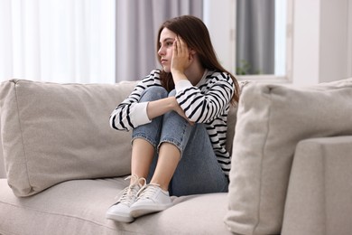 Loneliness concept. Sad teenage girl on sofa at home