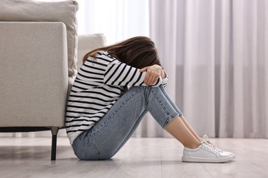 Photo of Loneliness concept. Sad teenage girl on floor at home