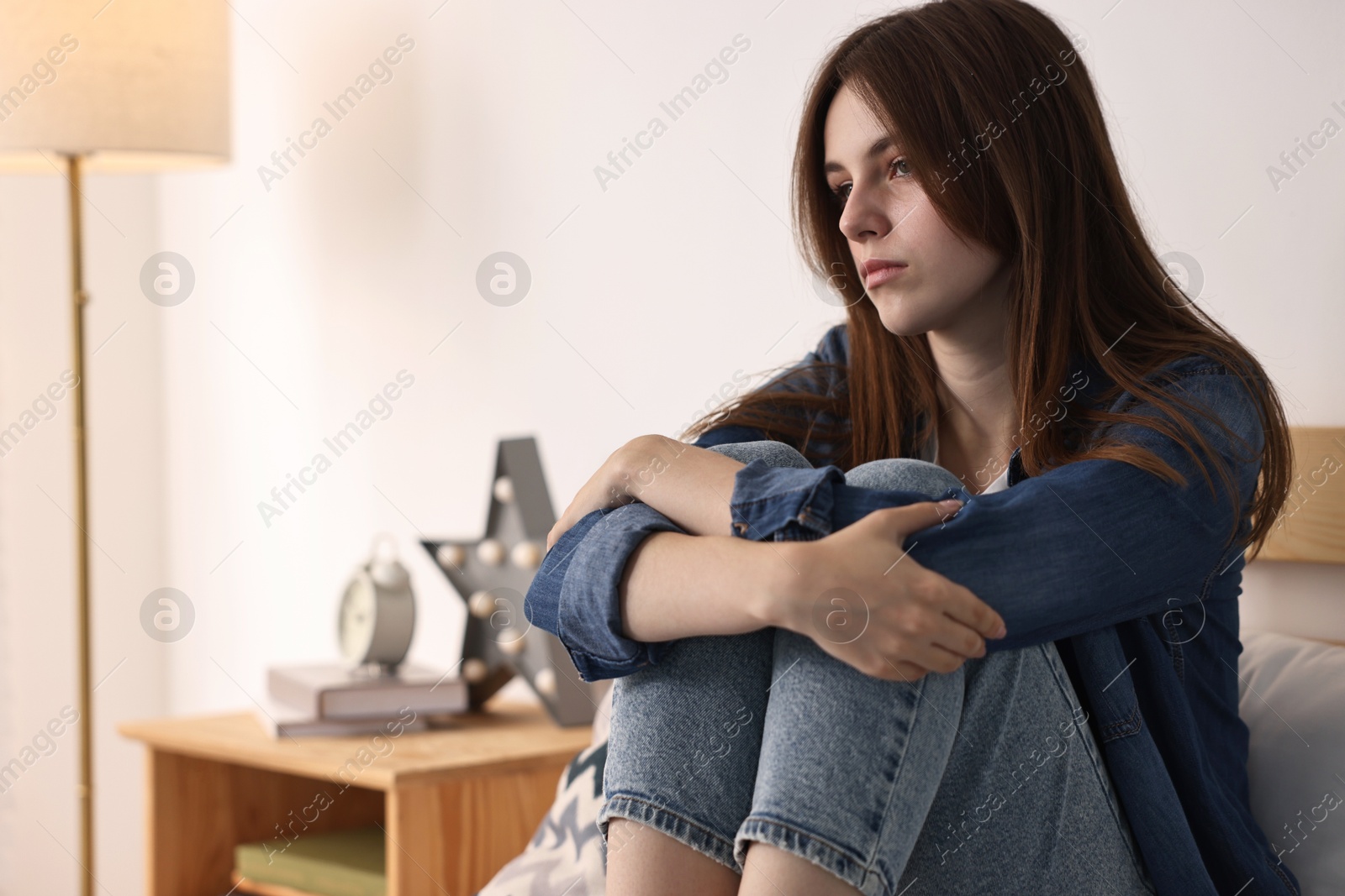 Photo of Loneliness concept. Sad teenage girl on bed at home