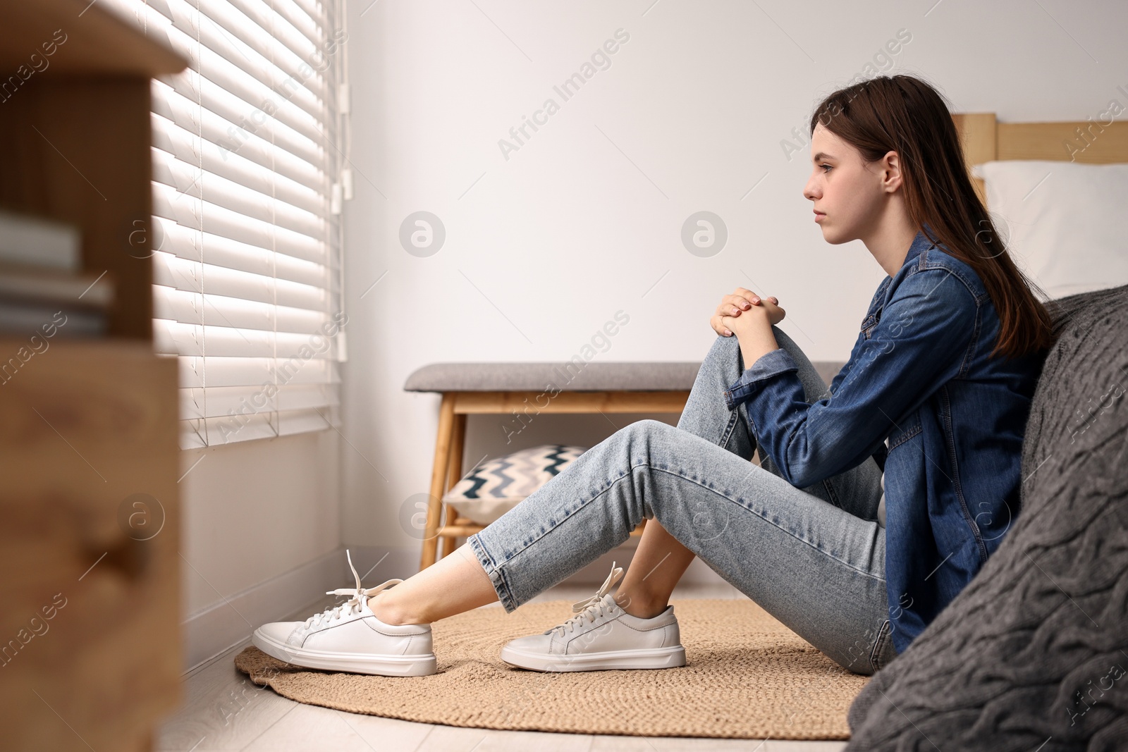 Photo of Loneliness concept. Sad teenage girl on floor at home