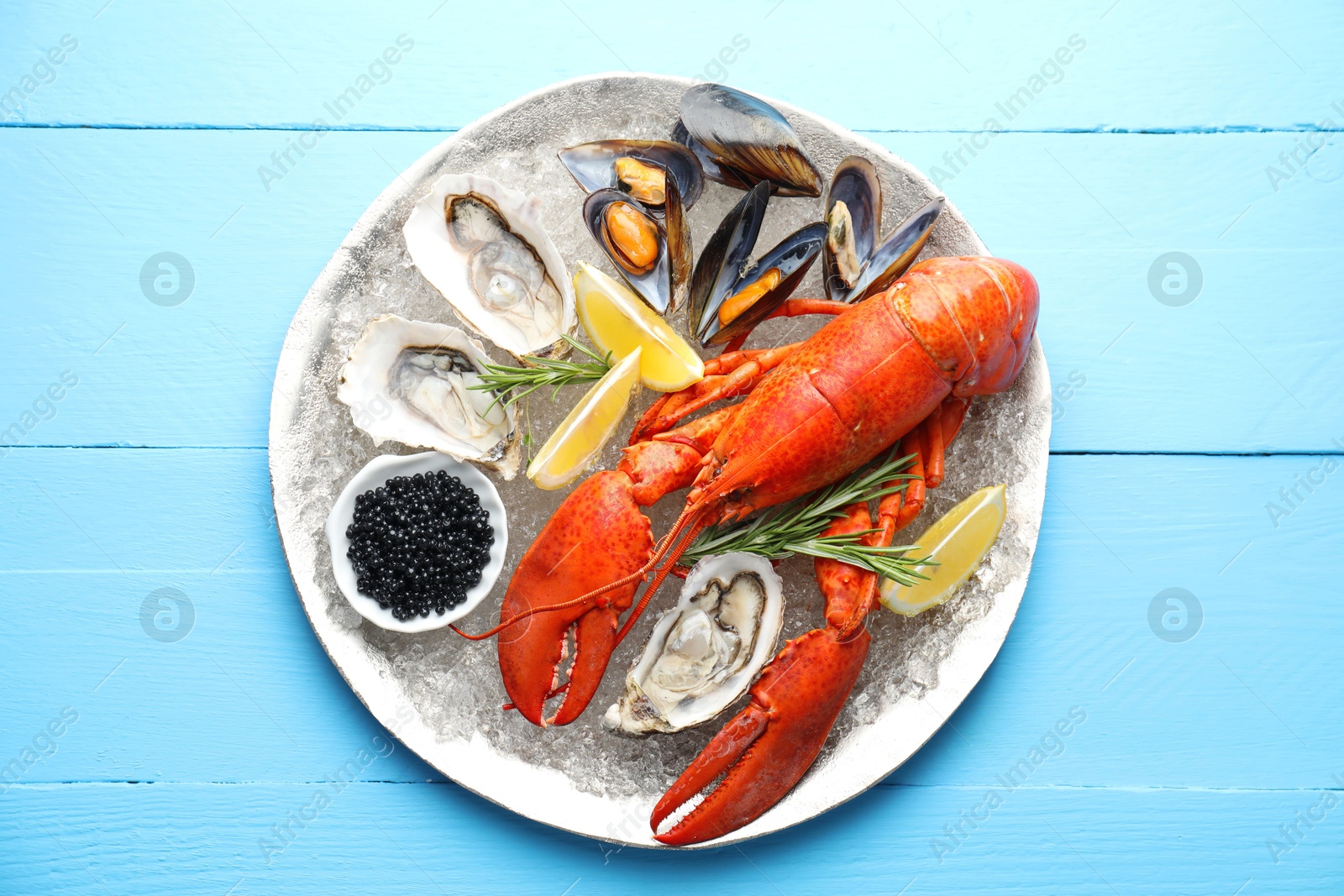 Photo of Many different sea food on light blue wooden table, top view