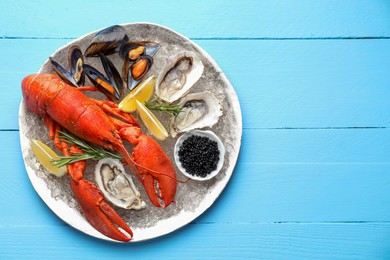 Photo of Many different sea food on light blue wooden table, top view. Space for text