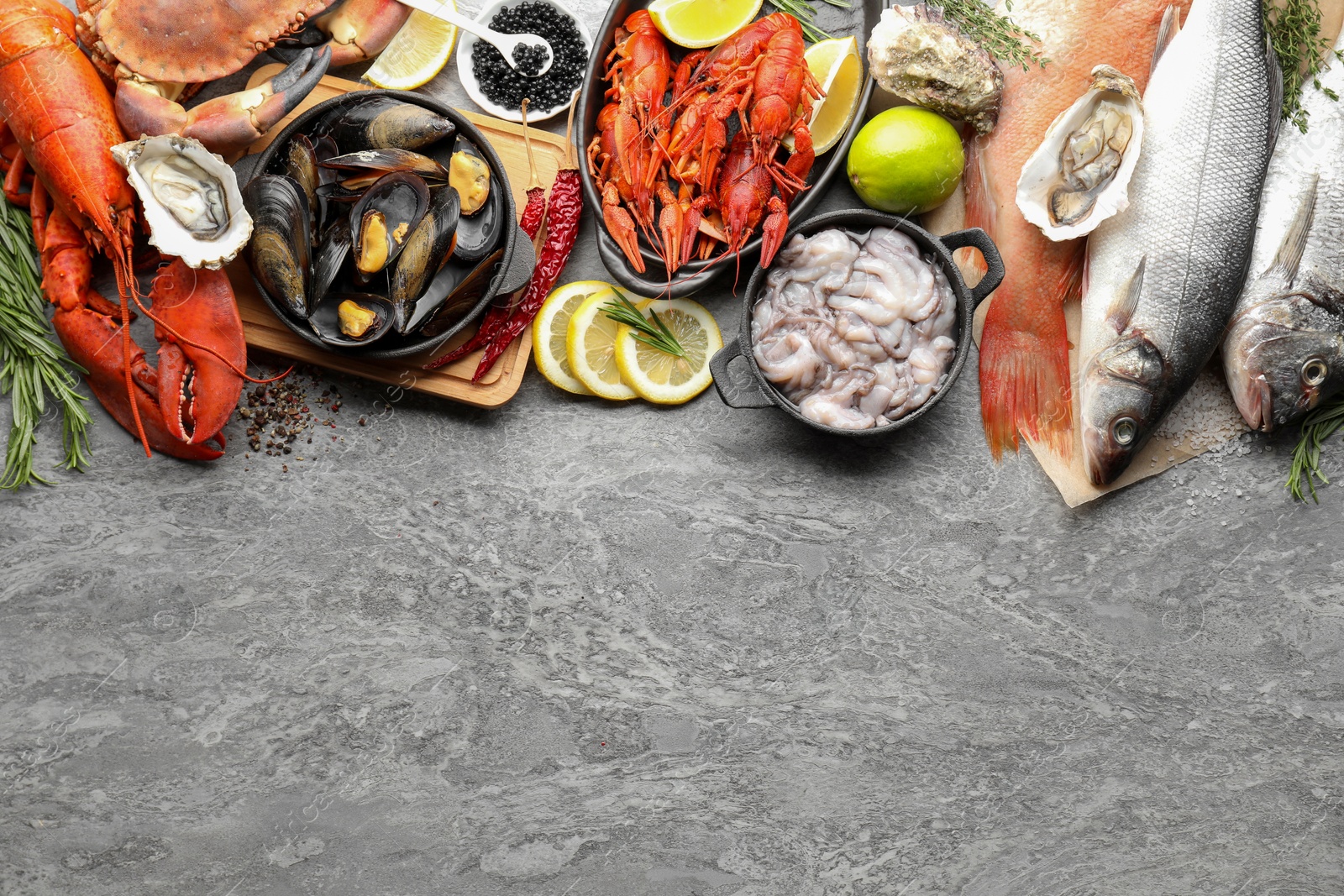 Photo of Many different sea food on grey table, top view