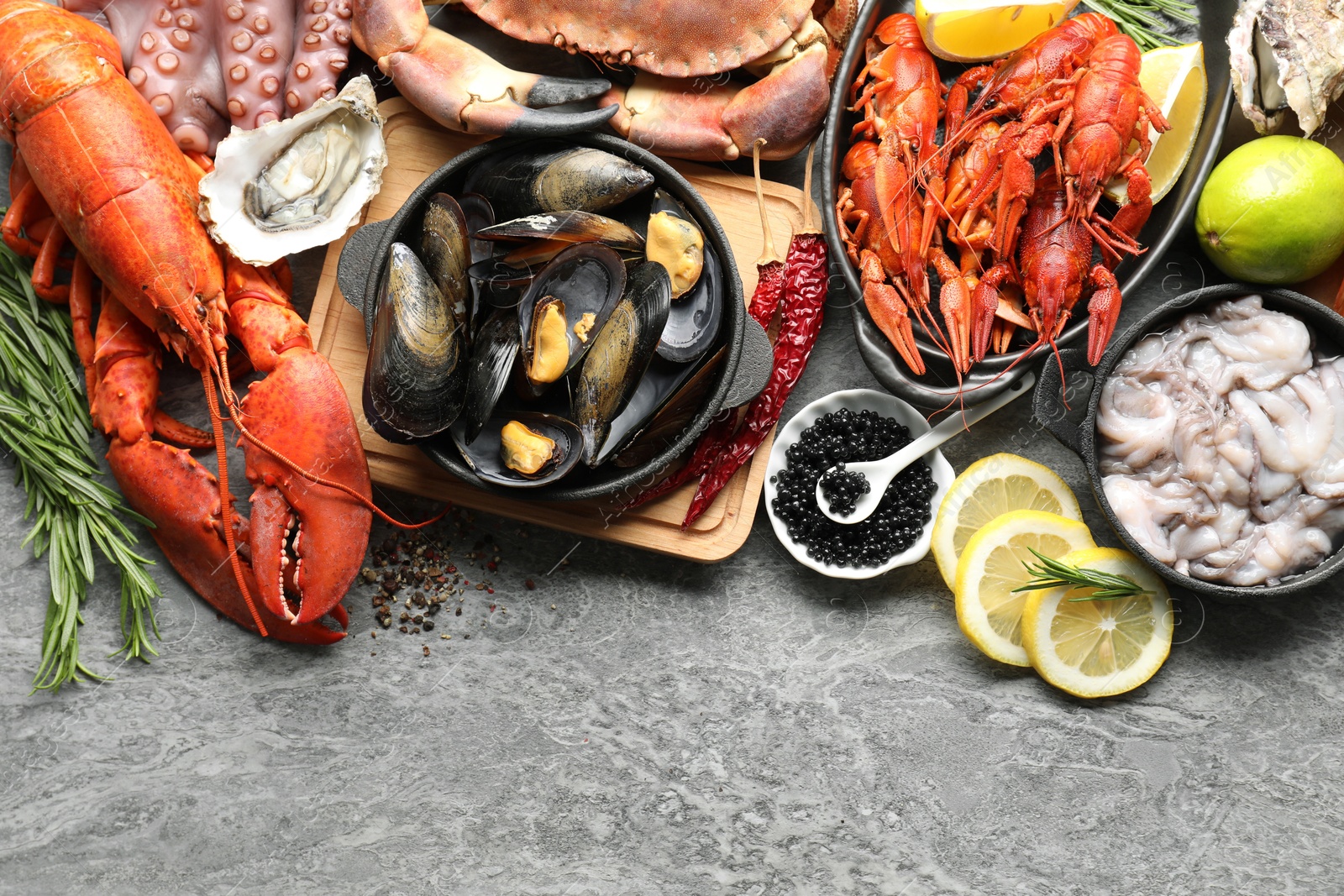 Photo of Many different sea food on grey table, top view