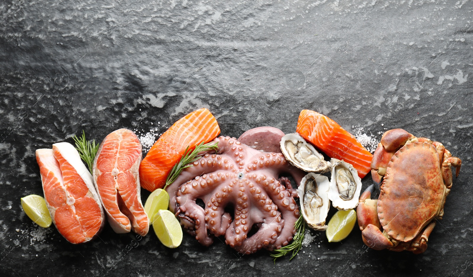 Photo of Many different sea food on dark table, top view