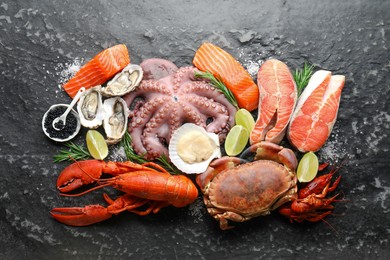 Photo of Many different sea food on dark table, top view