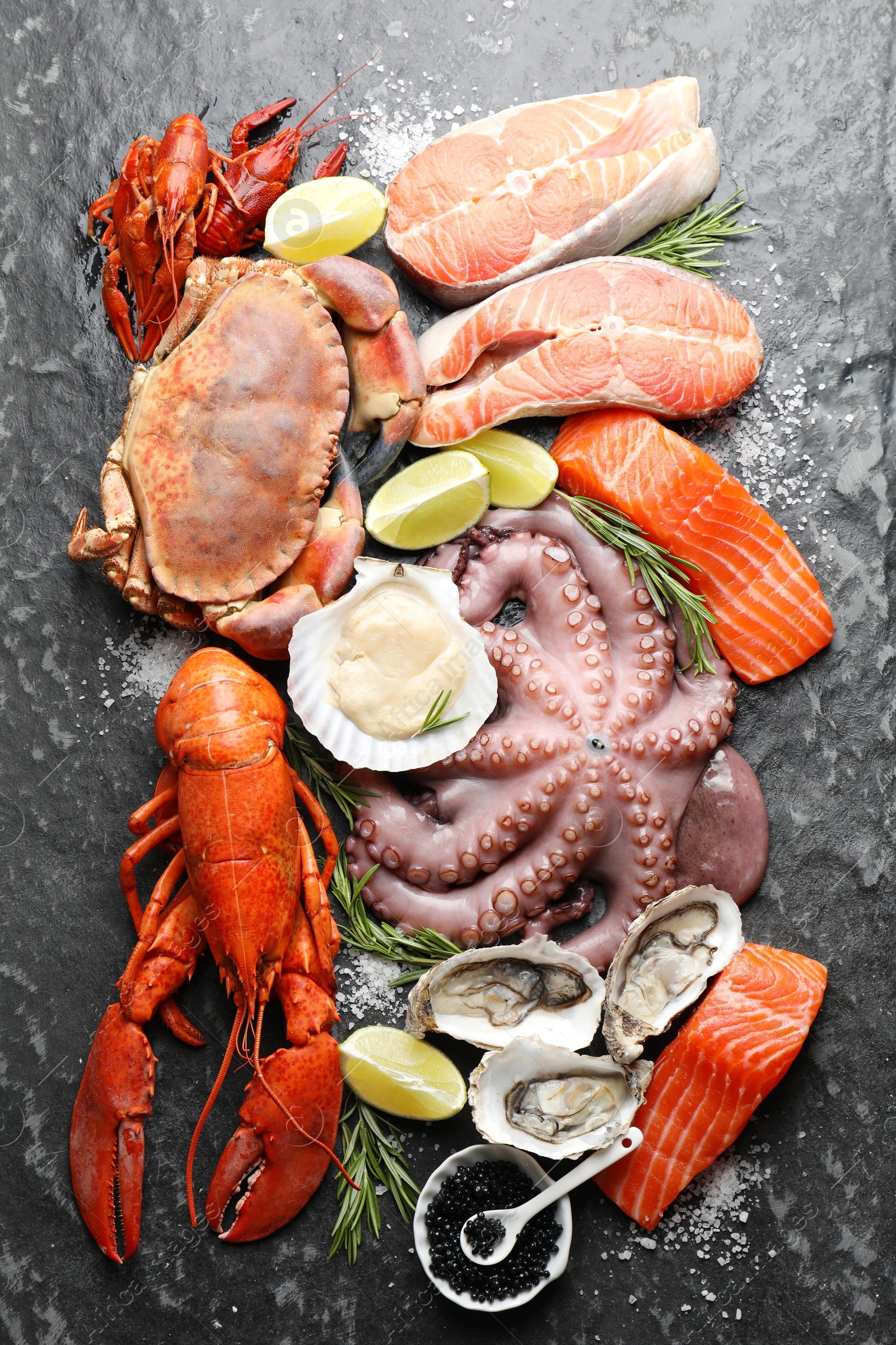 Photo of Many different sea food on dark table, top view