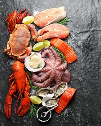 Photo of Many different sea food on dark table, top view