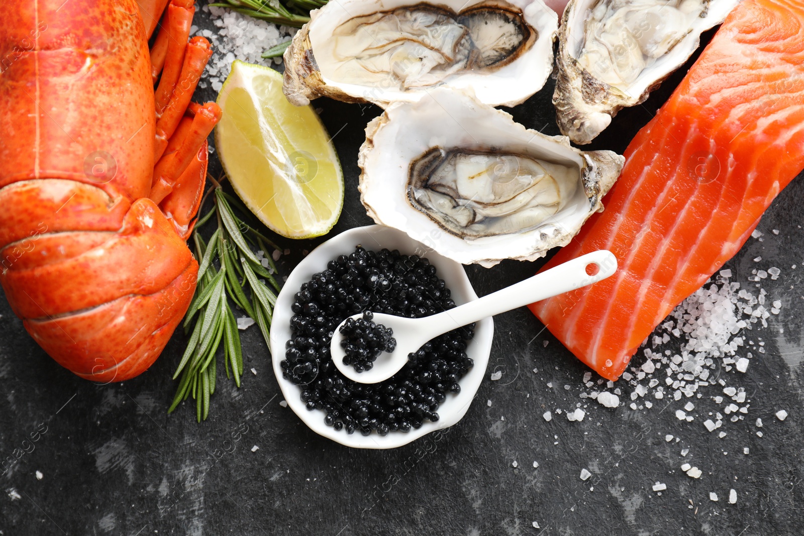 Photo of Many different sea food on dark table, top view