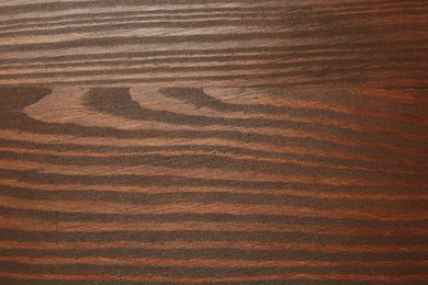 Photo of Applying walnut wood stain. Texture of wooden surface as background, top view