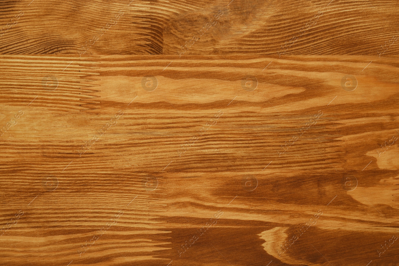 Photo of Applying walnut wood stain. Texture of wooden surface as background, top view