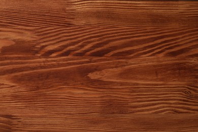 Photo of Applying walnut wood stain. Texture of wooden surface as background, top view