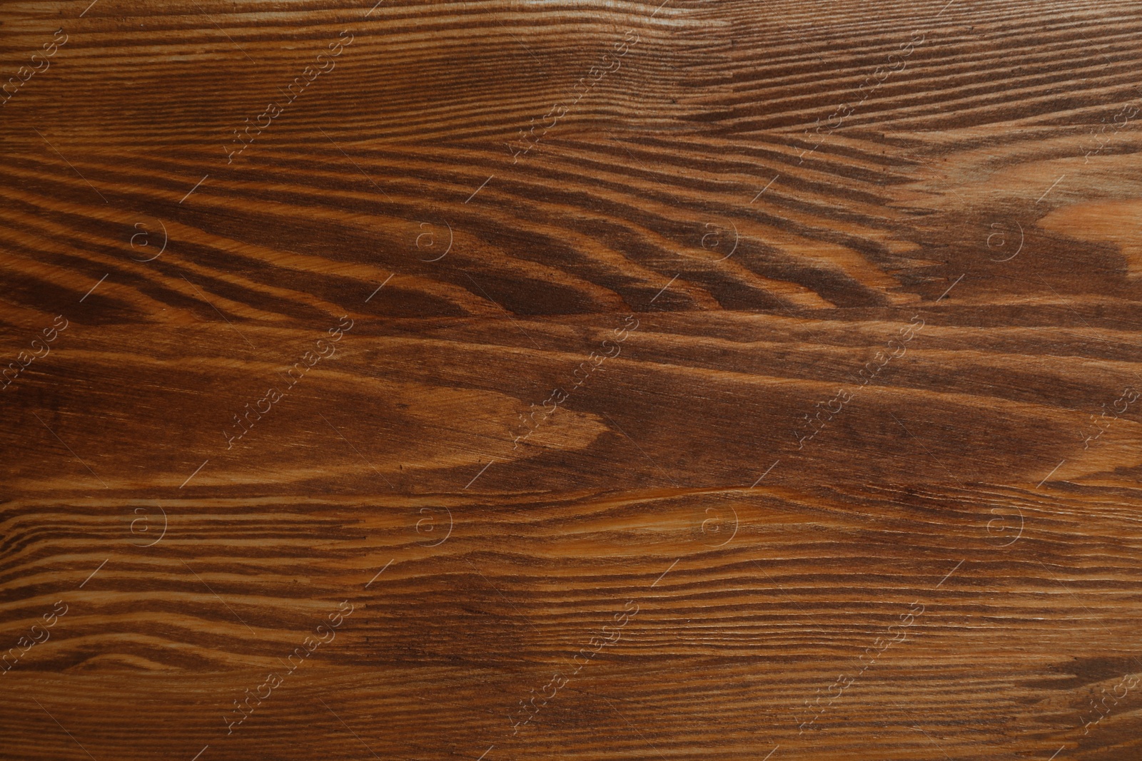 Photo of Applying walnut wood stain. Texture of wooden surface as background, top view