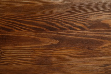 Photo of Applying walnut wood stain. Texture of wooden surface as background, top view