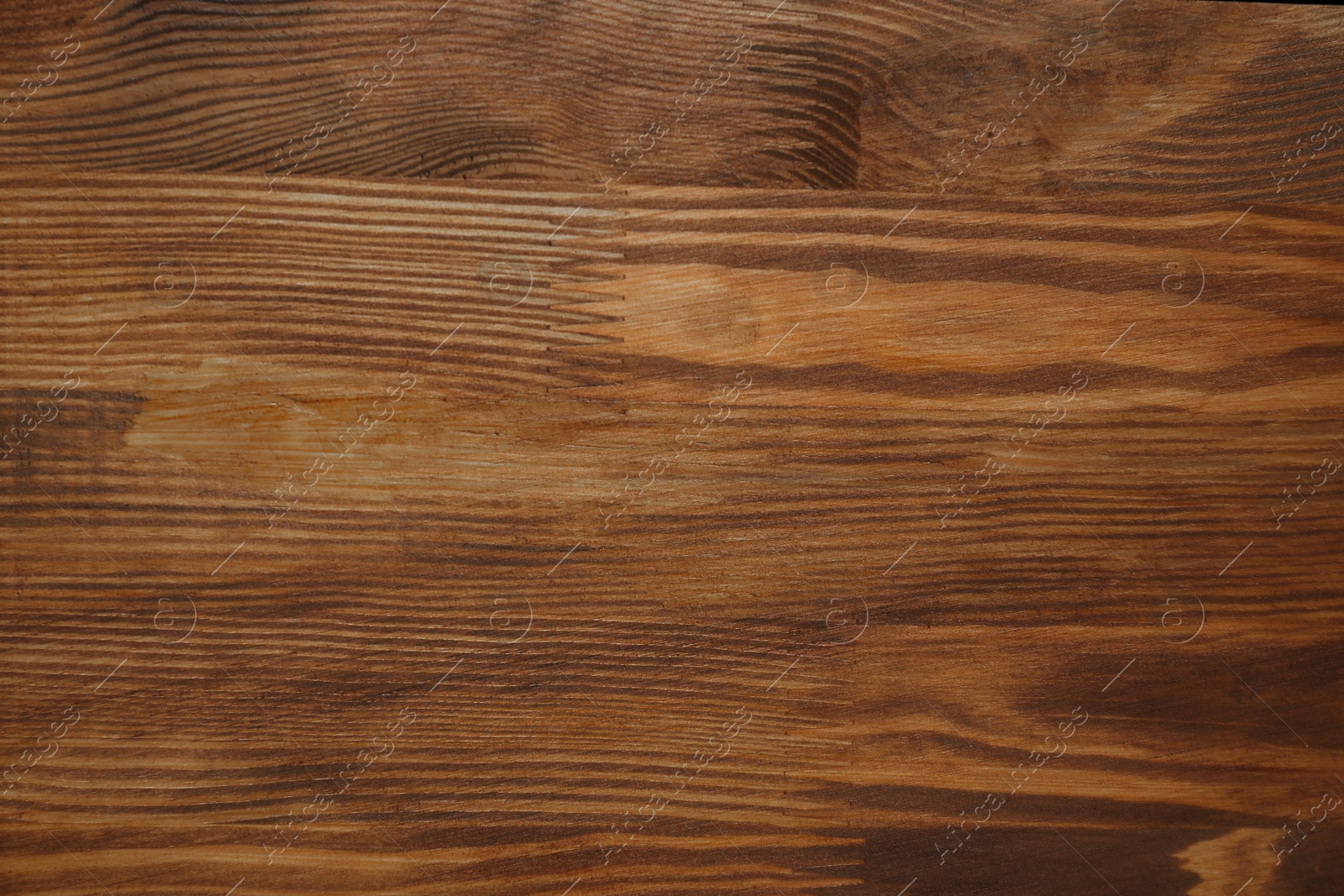 Photo of Applying walnut wood stain. Texture of wooden surface as background, top view