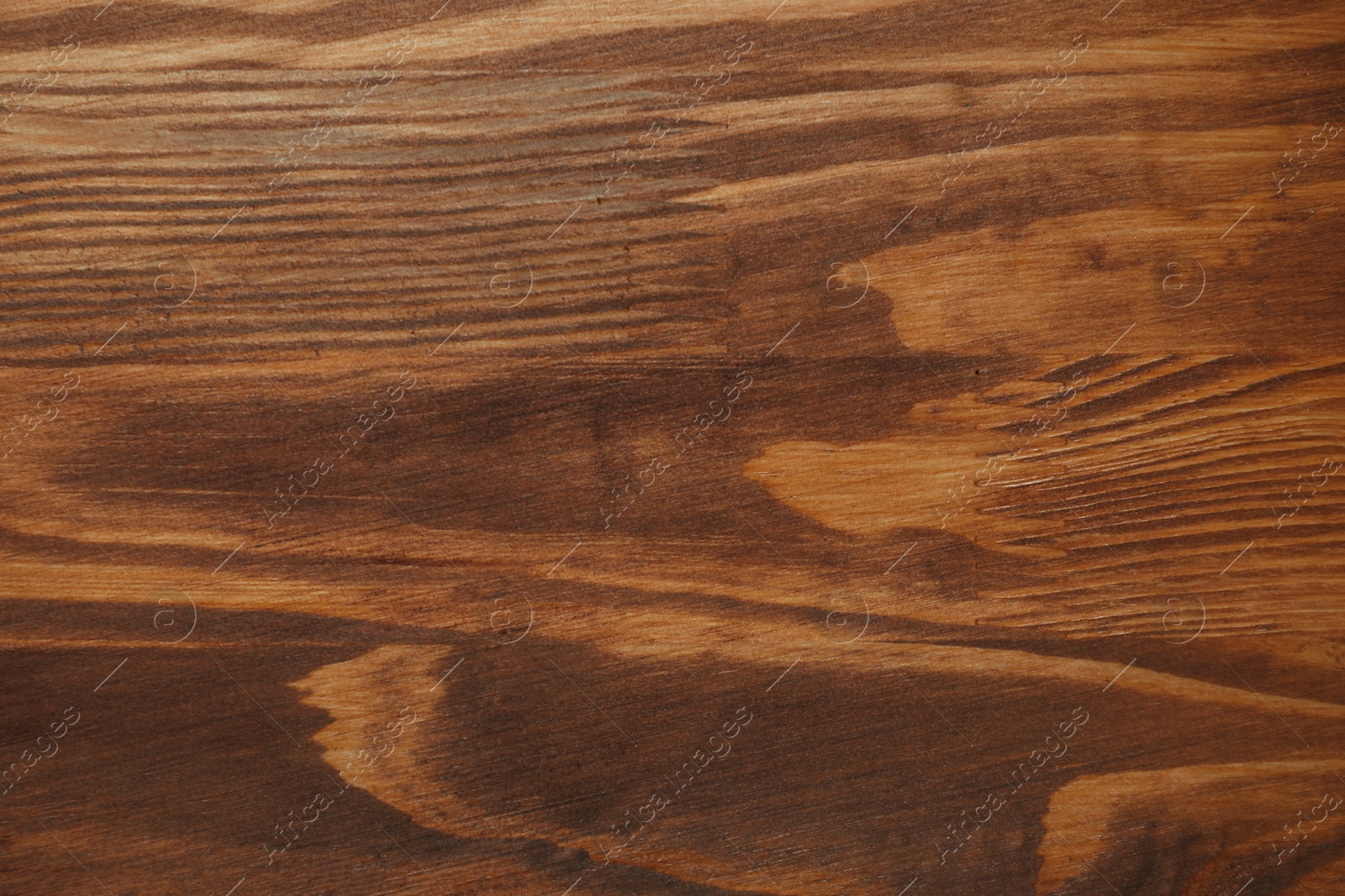 Photo of Applying walnut wood stain. Texture of wooden surface as background, top view