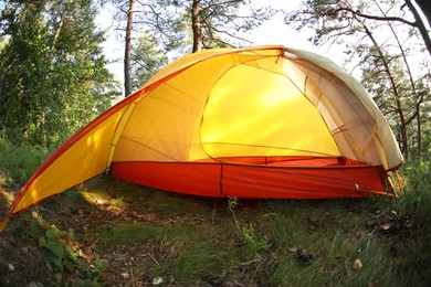 Photo of Modern camping tent in forest at summer, low angle view