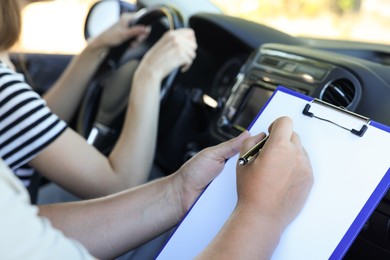 Driving school. Student passing driving test with examiner in car, closeup