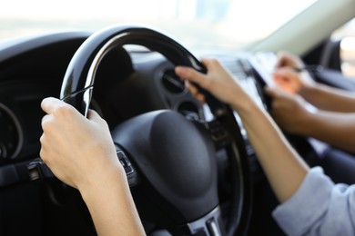 Photo of Driving school. Student passing driving test with examiner in car, closeup